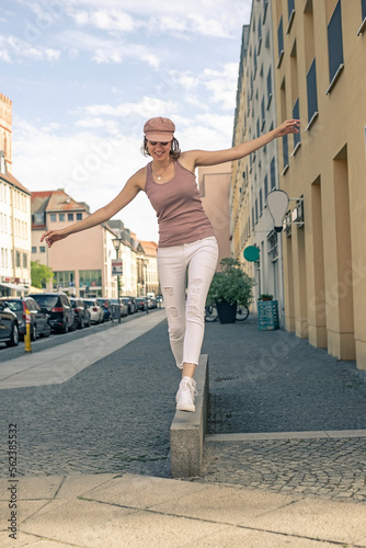 glückliche junge Frau balanciert  in der Stadt