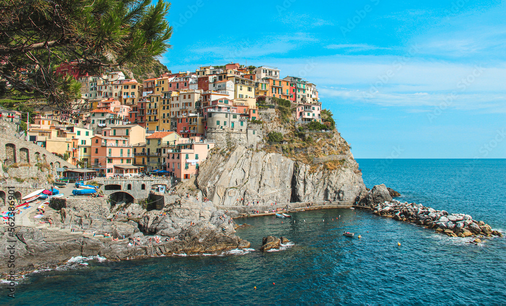 Scenes of Cinque Terre (Manarola) with colorful houses built on the cliff side  in a sunny day