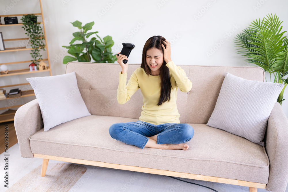 Asian Woman playing video games at home. .Cheerful gamer playing online games with console Asian Woman playing video games at home. .Cheerful gamer playing online games with console