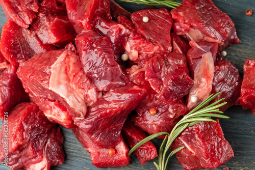 Slices of sliced raw beef close-up with rosemary, top view.