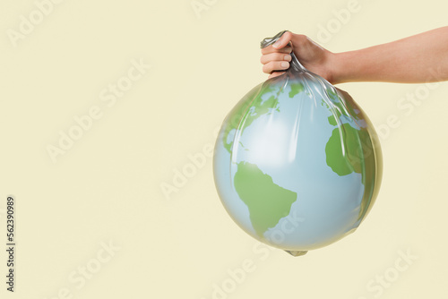crop anonymous person showing plastic bag with globe
