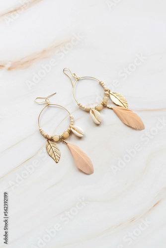 A pair of earrings on a marble background with copy space. Fashion earrings for women.
