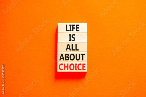 Choice and life symbol. Concept words Life is all about choice on wooden blocks. Beautiful orange table orange background. Business choice and life concept. Copy space.