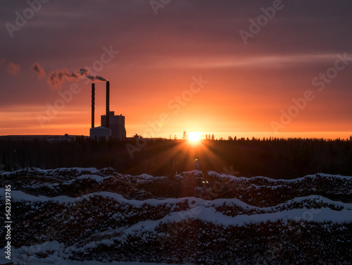 Sun setting behing wood factory in the winter in Rovaniemi, Finland.