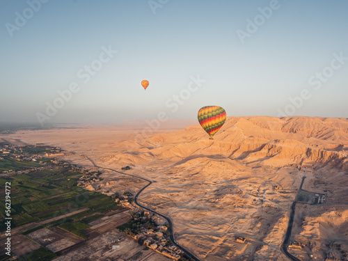 Aerial view of the agricultural fields, Luxor the desert and balloons from a hot air balloon during sunrise.