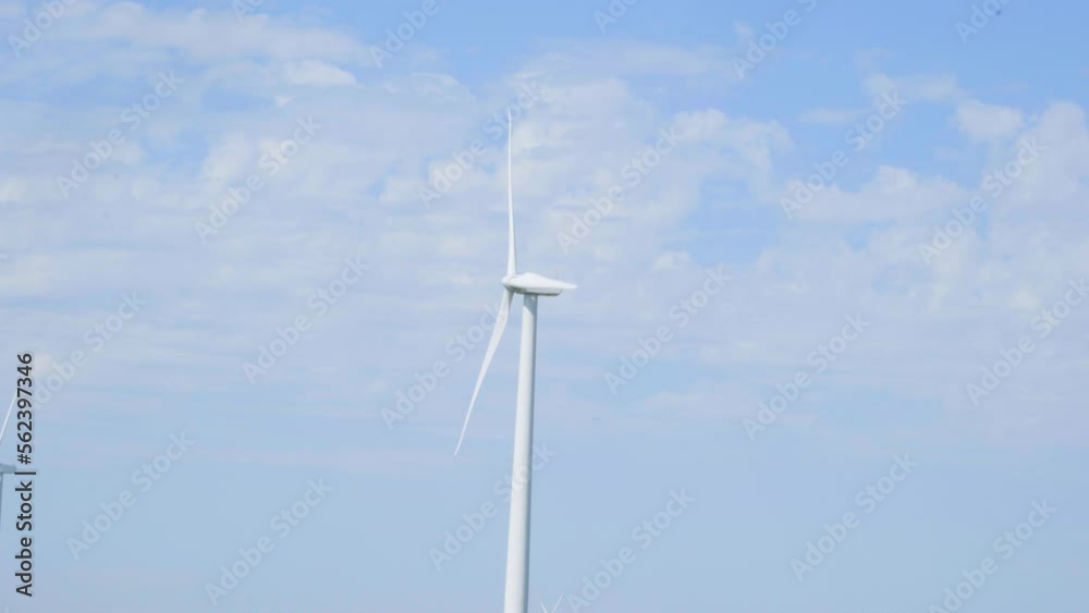 Clean sustainable wind turbine electrical energy generator rotating blades against blue sky Clean sustainable wind turbine electrical energy generator rotating blades against blue sky