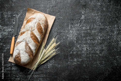 Fresh bread with spikelets and a knife.