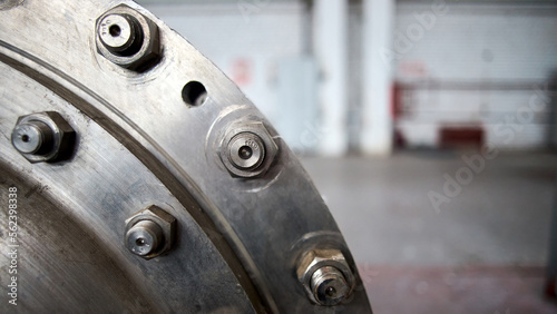Sealing connection bolted screw connection, on manhole of industrial machine compressor or pump on chemical plant selective focus with out of focus abstract industrial background with copyspace 16x9.
