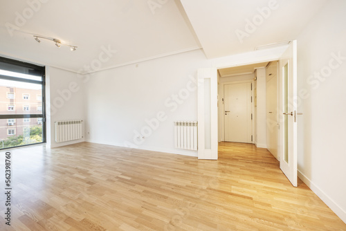 Wallpaper Mural Room of an empty house with gloss oak parquet floors with black anodized aluminum window and aluminum radiator on the walls, white access door and carpentry of the same color Torontodigital.ca