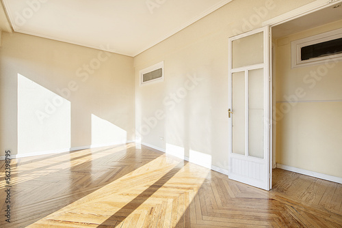 Empty room with white wooden doors with wooden floor and glass