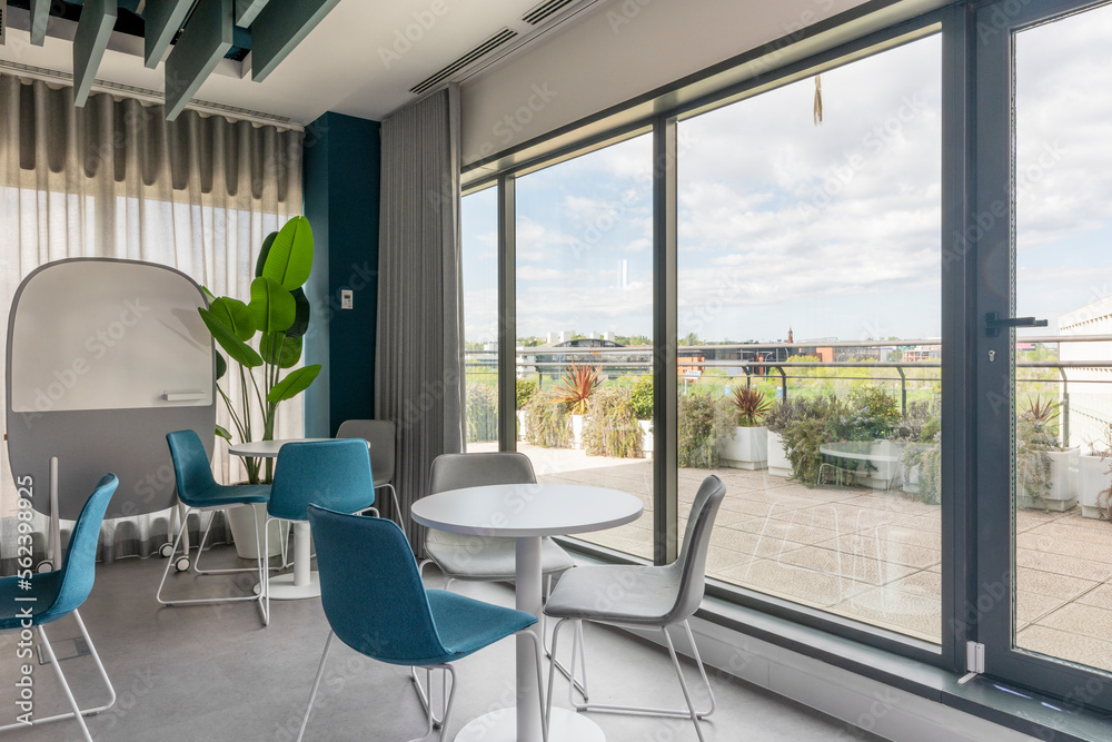 Fototapeta premium A coworking office with rest tables next to a terrace with views