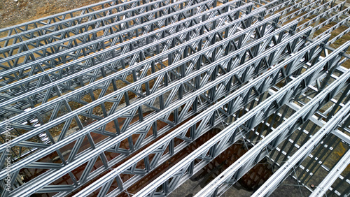 Building construction from metal trusses. lattice structure of the frame of an industrial building. A large thick tangle on the ceiling of a building under construction. shiny metal profiles steel photo