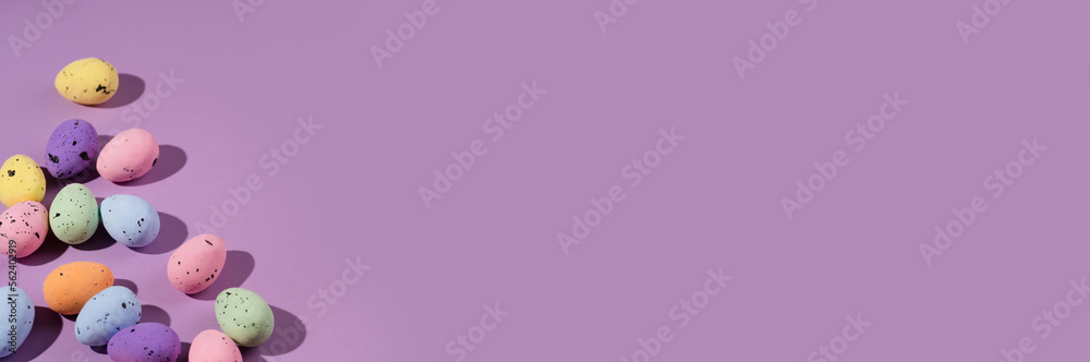 Bunch of colorful eggs with dots on purple background. Minimal Easter concept with copy space for text. 