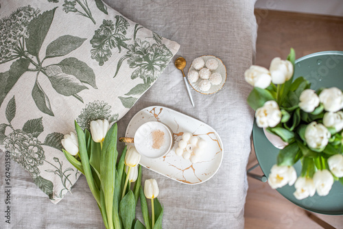 Cup with cappuccino, spring flowers tulips, morning concept, soy candle, woman's day