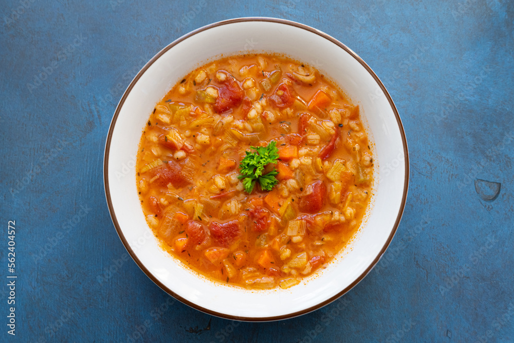 barley and vegetable soup on blue background barley and vegetable soup on blue background