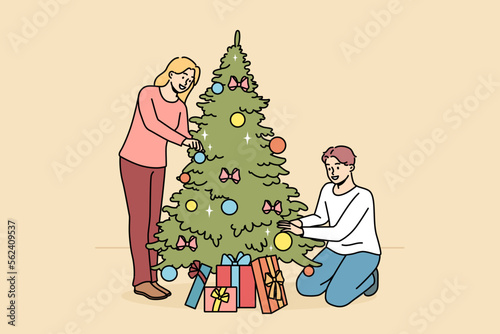 Happy couple decorate fir-tree with balls and bulbs together. Smiling man and woman enjoy Christmas tree decoration at home for winter holidays. Vector illustration. 