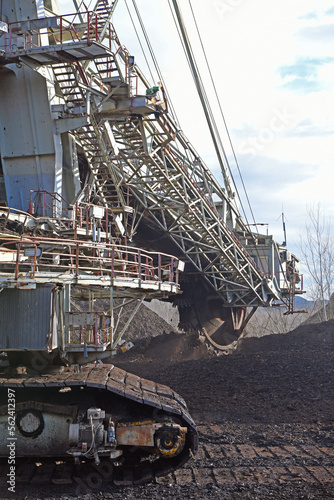 Bucket-wheel excavator during excavation at the surface mine. Huge excavator on open pit mine.