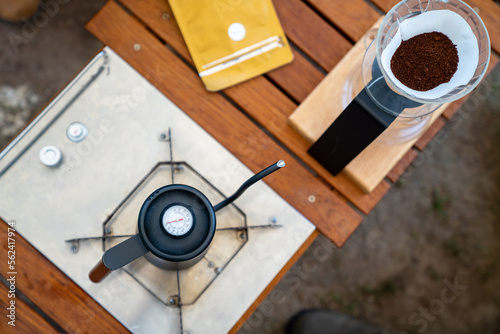 Drip coffee makers on outdoor camping table. Group of People enjoy outdoor lifestyle travel nature having breakfast and drinking brewed coffee at camp in the morning on summer travel vacation.