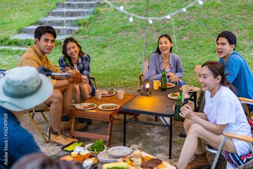 Group of Happy Asian people enjoy and fun outdoor lifestyle travel nature hiking and camping on summer holiday vacation. Man and woman friends cooking food and having dinner together at camp at night.