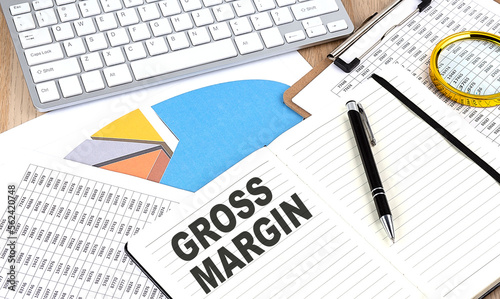 GROSS MARGIN text on notebook with chart and keyboard