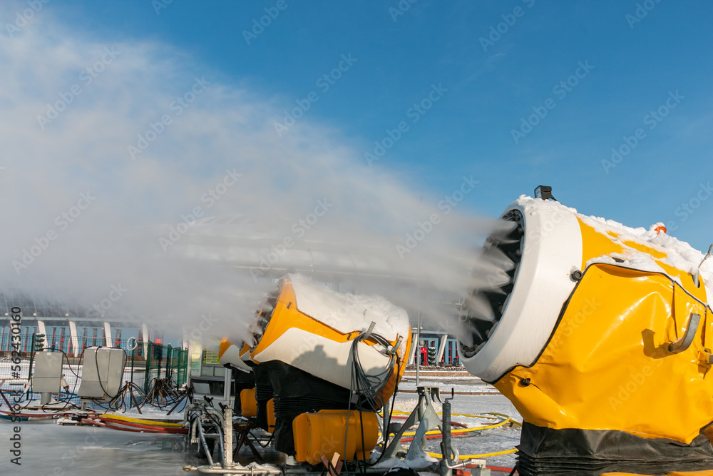 Snow cannons spray artificial snow crystals. Production of artificial snow. Snow guns. Cars make snow.