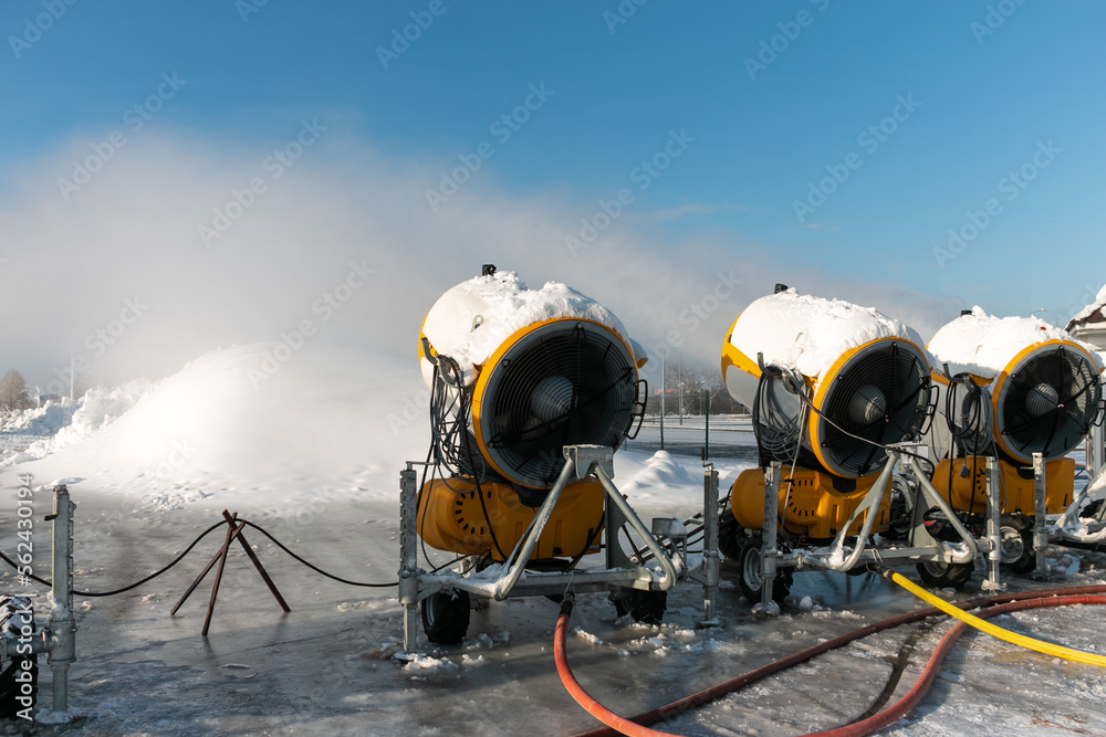 Three snow cannons spray artificial snow crystals. Production of artificial snow. Cars make snow. Snow guns.