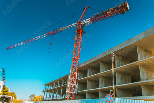 Obraz na płótnie Construction crane at a construction site in the city against the blue sky. The concept of building a new area. Construction of a new building. w salonie