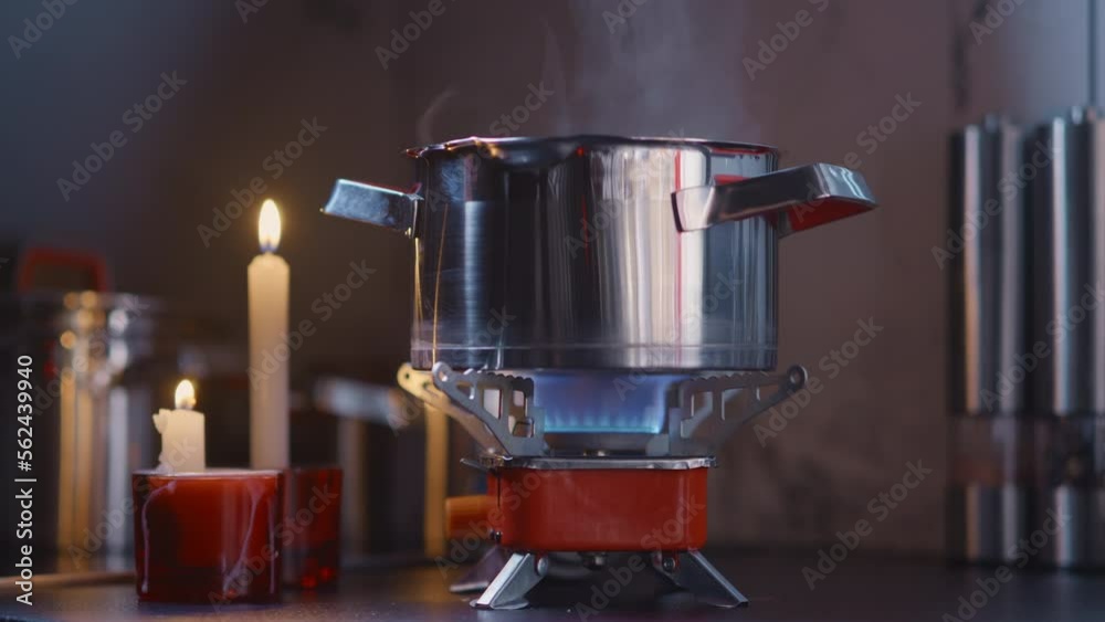 Cooking diner on a portable stove during blackout, tourist gas burner