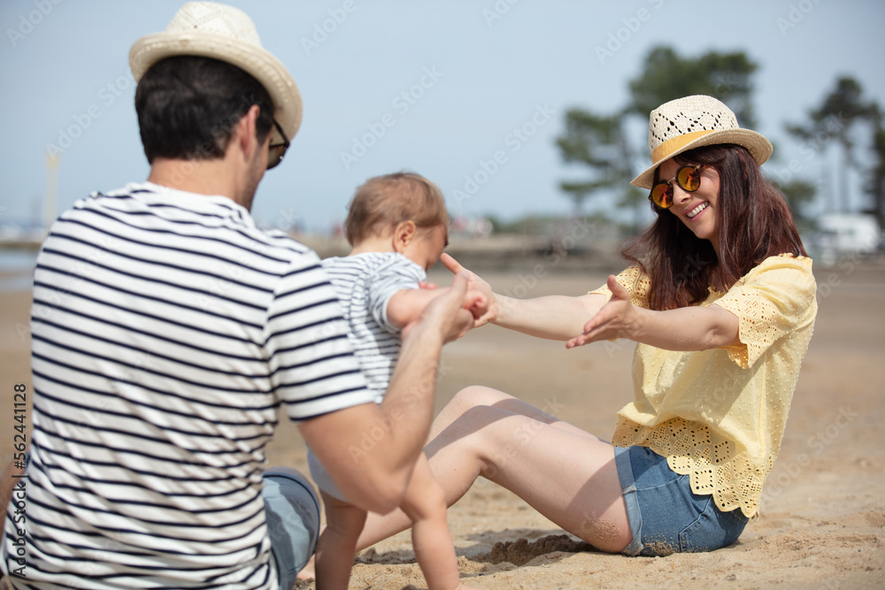 young family with baby outdoors on ocean