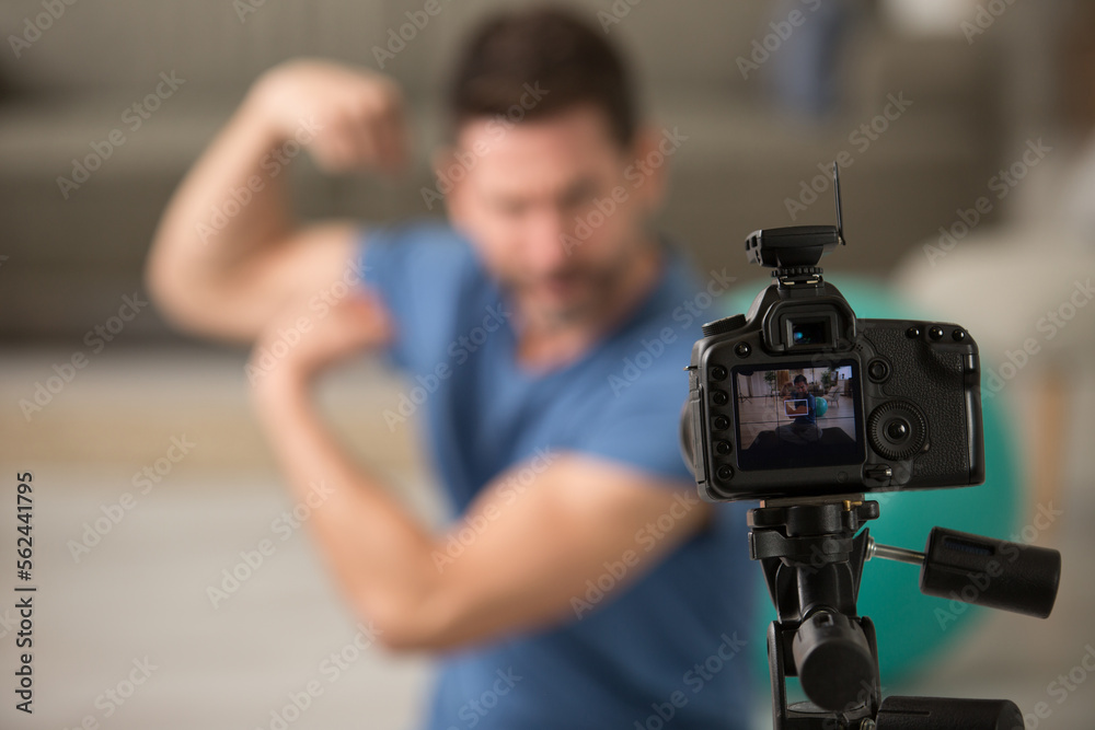 male fitness instructor making home video about muscle grow