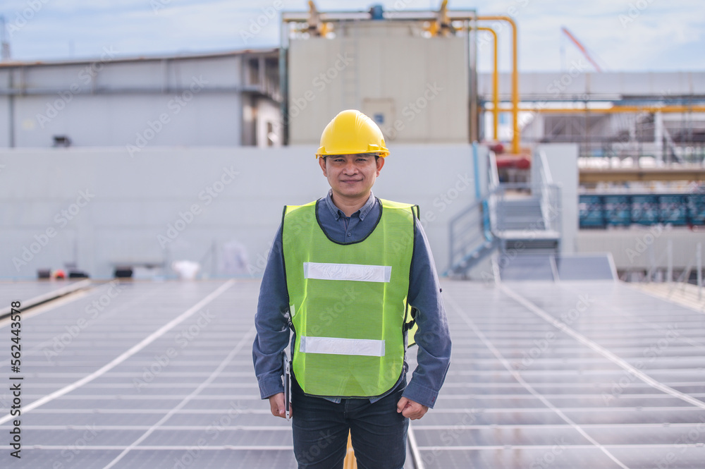 Asian engineer using tablet checking in solar power system for industrial ecology control top roof factory Asian engineer using tablet checking in solar power system for industrial ecology control top roof factory
