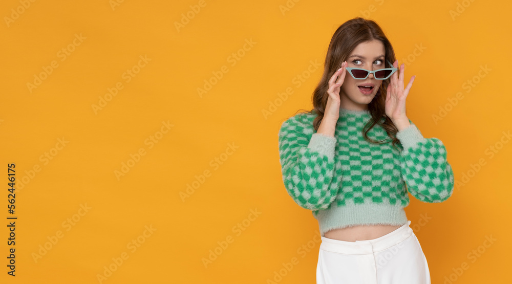 Gorgeous young woman with pretty smile in green sweater on orange background. Gorgeous young woman with pretty smile in green sweater on orange background.
