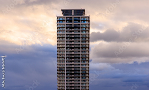 Sunset color in cloudy sky behind tall residential apartment building