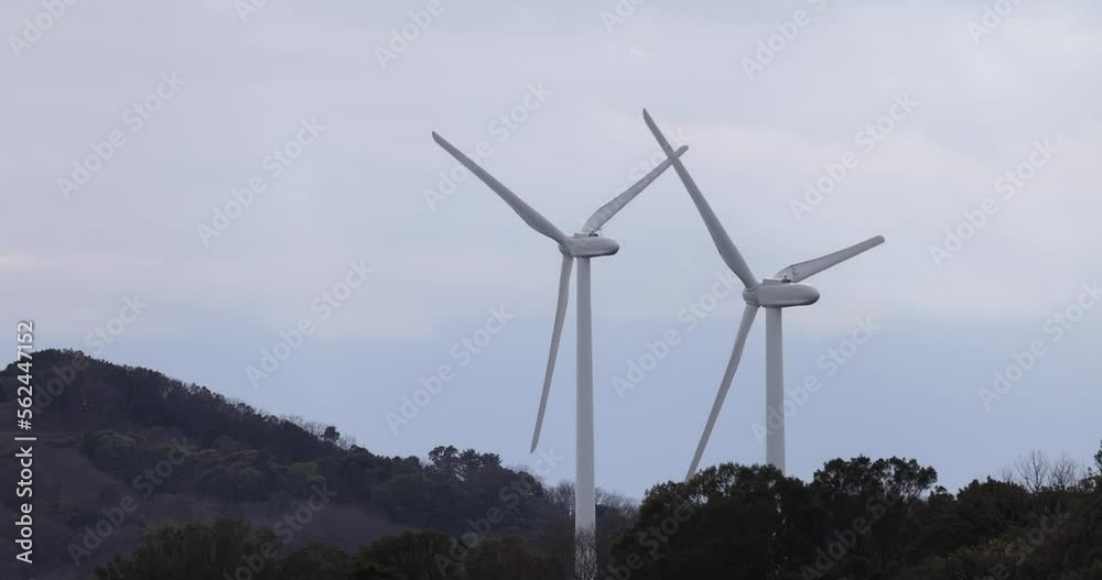 Two Wind Turbines Spinning in Slow Motion on Hill Two Wind Turbines Spinning in Slow Motion on Hill