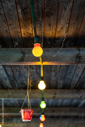 Colorful lights of the lamps on the wooden roof outside the house