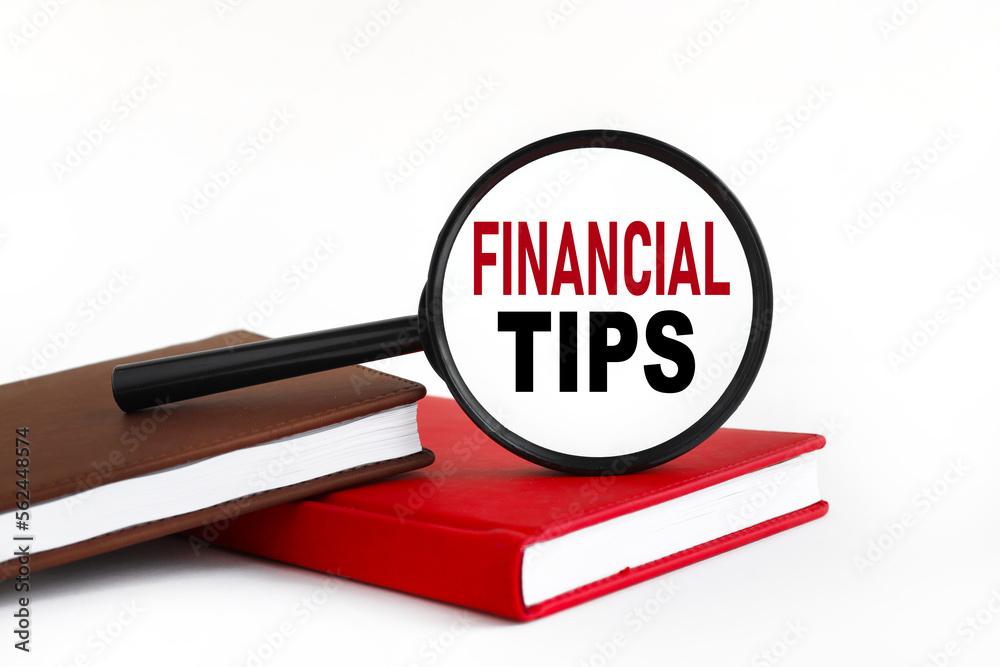 FINANCIAL TIPS words. text on a white background on glass. on the work table FINANCIAL TIPS words. text on a white background on glass. on the work table