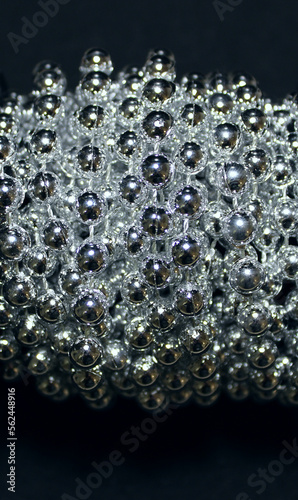 Shiny balls of a long beads are wound on a roll closeup stock photo 