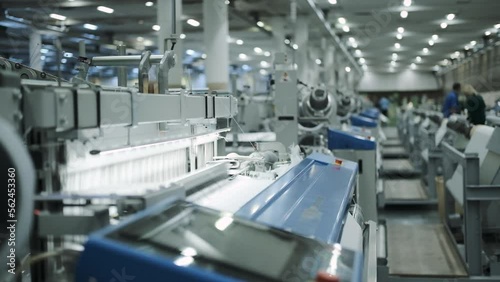 industrial workshop for the production of fiberglass fabric. factory. automation mechanisms produce the fabric and distribute it along the conveyor. production
