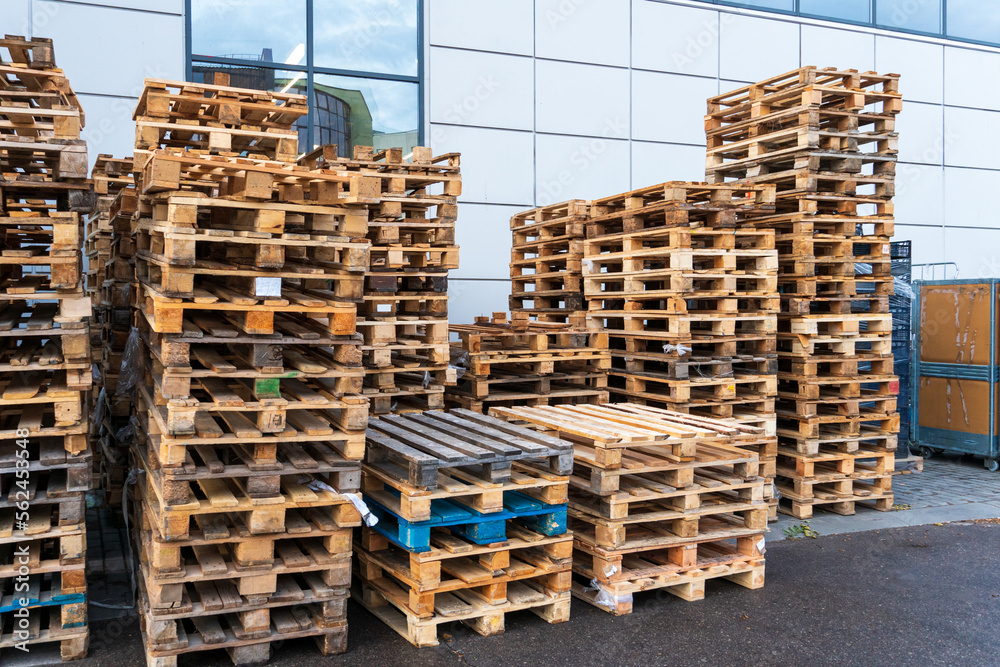 A stack of wooden pallets in an internal warehouse. An outdoor pallet storage area under the roof next to the store. Piles of Euro-type cargo pallets at a waste recycling facility. A stack of wooden pallets in an internal warehouse. An outdoor pallet storage area under the roof next to the store. Piles of Euro-type cargo pallets at a waste recycling facility.