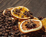 coffee beans with dried orange and cinnamon on a wooden background.