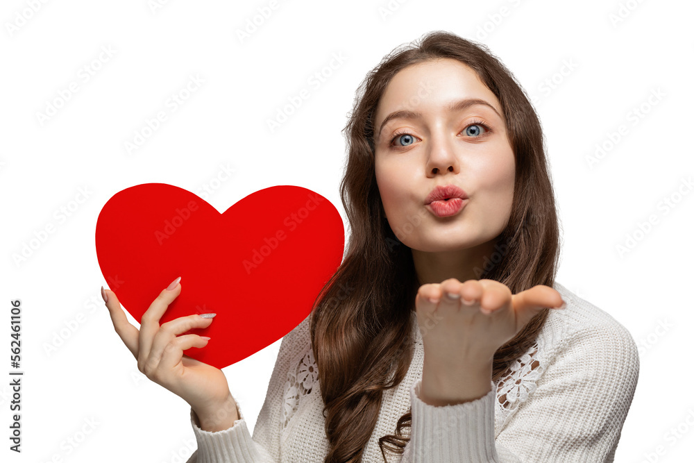 Beautiful teenage girl showing red heart from cardboard to camera and blows a kiss, valentine's day Beautiful teenage girl showing red heart from cardboard to camera and blows a kiss, valentine's day