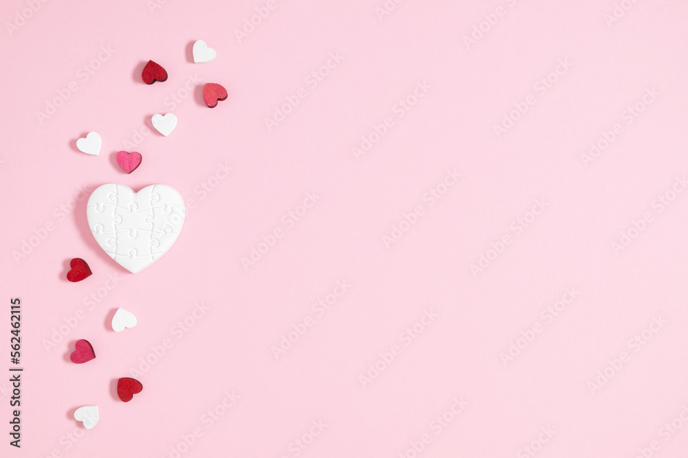 Valentine's Day background. White cute hearts confetti scattered on isolated pastel pink background. Valentine's day concept. Flat lay, top view, copy space