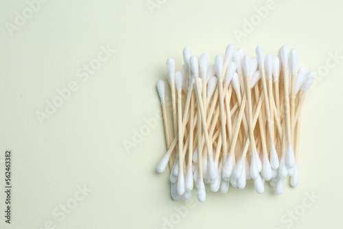 Heap of cotton buds on beige background, top view. Space for text