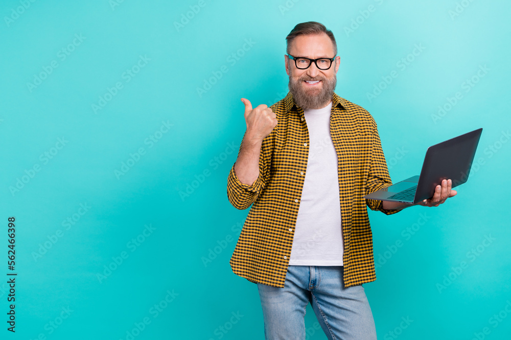 Photo of expert programmer middle age man stylish outfit show mockup finger hold netbook recommend website isolated on aquamarine color background Photo of expert programmer middle age man stylish outfit show mockup finger hold netbook recommend website isolated on aquamarine color background