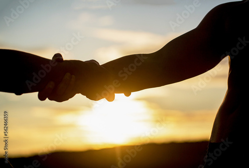Canvas Print Two hands silhouette on sky background, connection or help concept