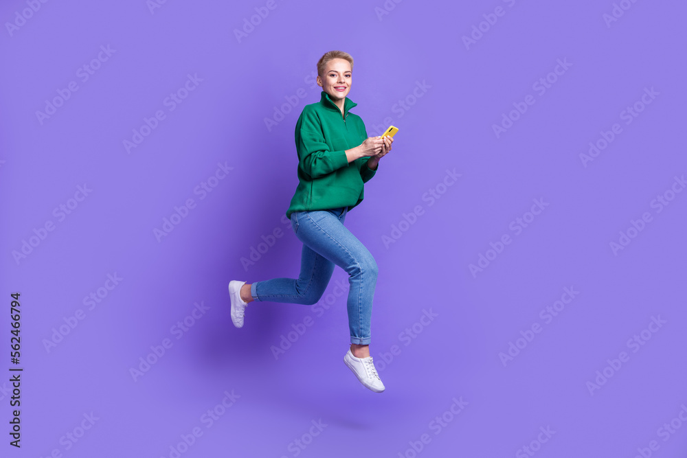 Full length profile portrait of carefree crazy person jump rush hurry use telephone isolated on purple color background