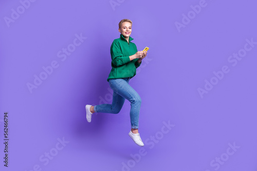 Full length profile portrait of carefree crazy person jump rush hurry use telephone isolated on purple color background © deagreez