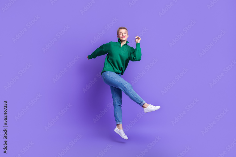Full length photo of dreamy pretty lady wear green sweater having fun dancing jumping high isolated violet color background