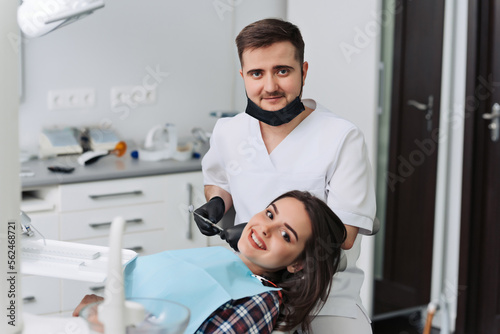 The girl is at the reception at the dentist. A happy client at the dentist smiles. Dental bleaching. Dental clinic. Treatment of teeth in a modern clinic.