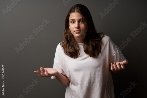 Teen girl with confused expression and arms opened making asking gesture photo